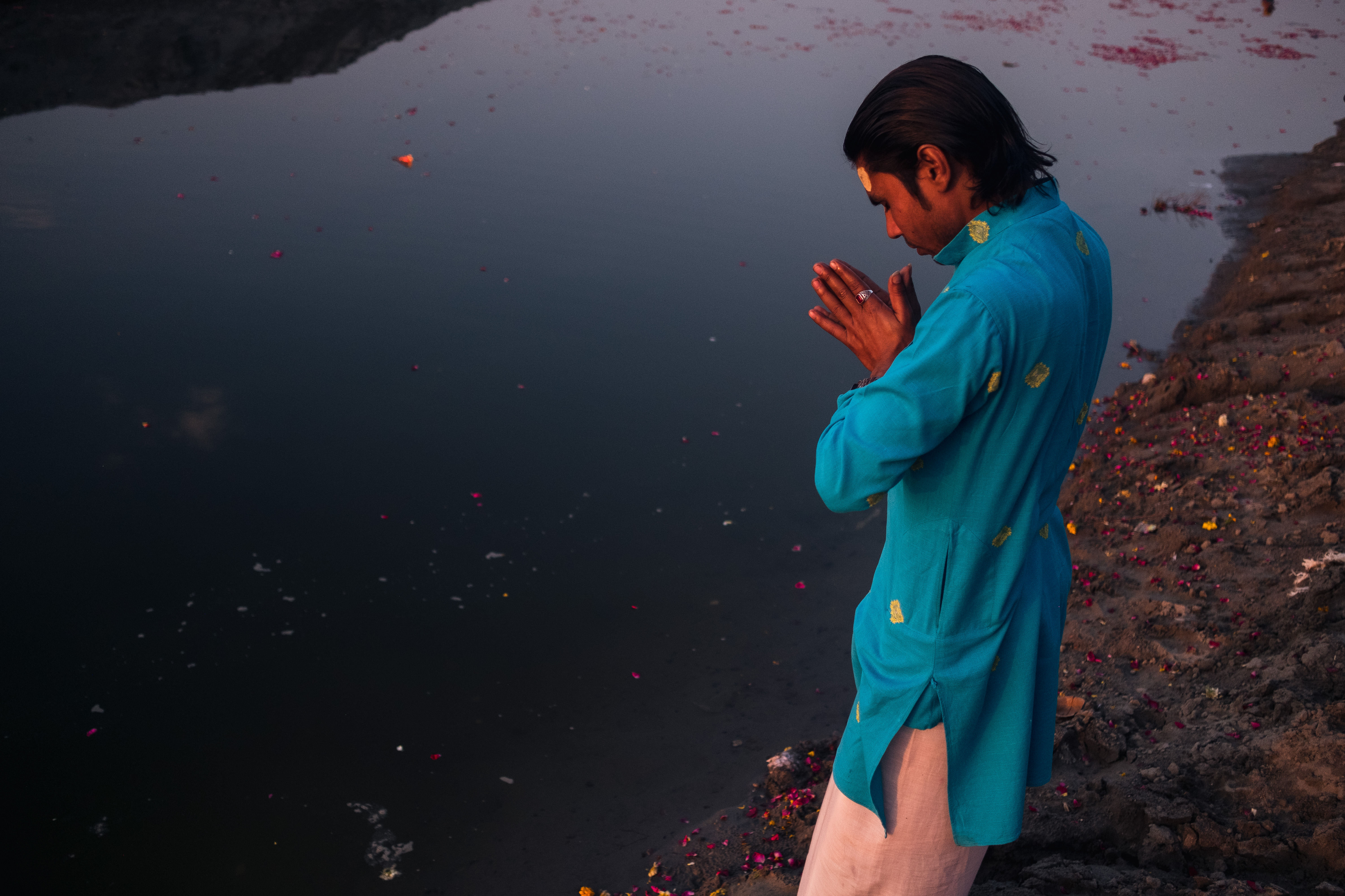 India Street Photography During Holi Festival. Man prays on the waters edge. Images by Jason Vinson
