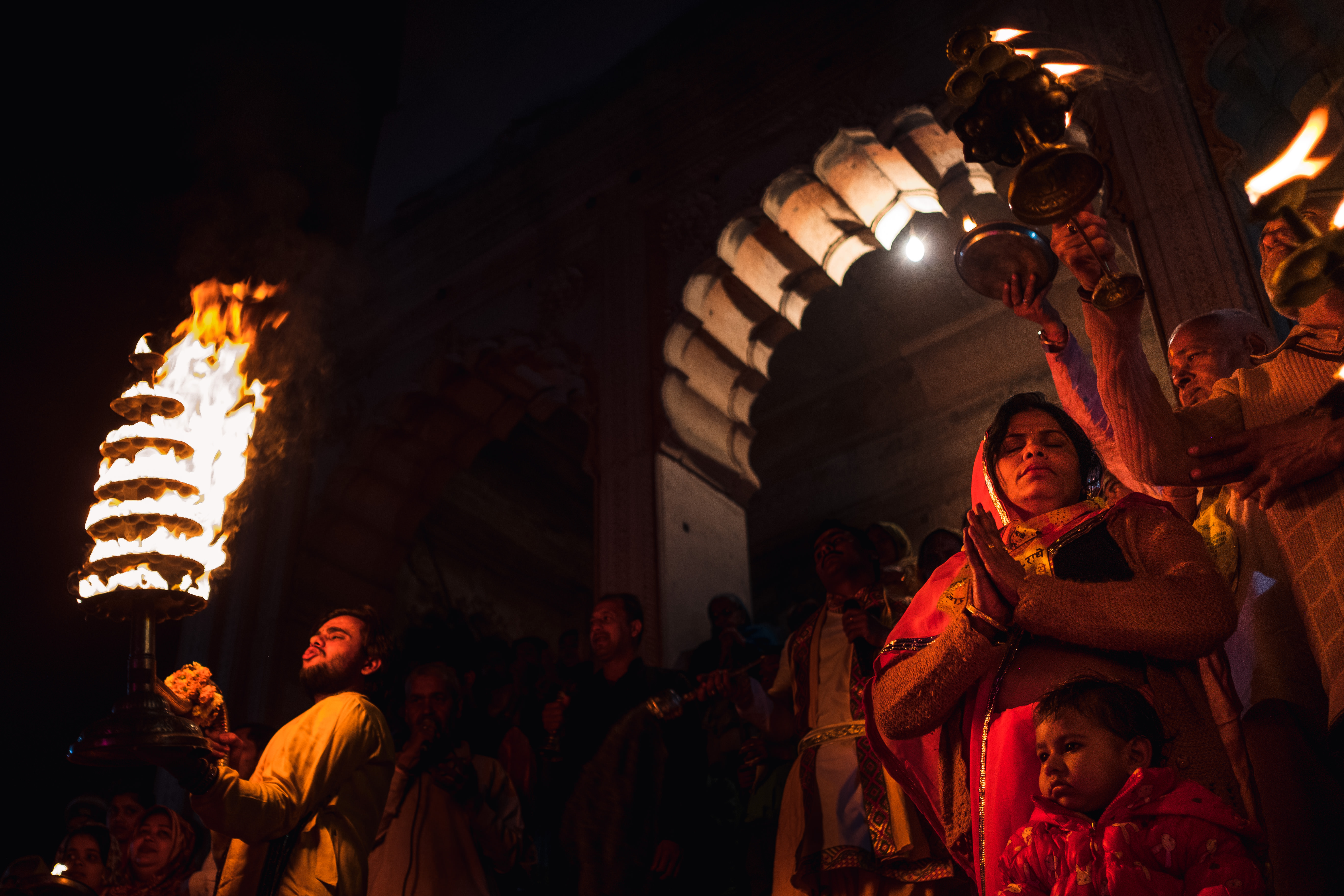 India Street Photography During Holi Festival. people pray as fire is displayed in dance. Images by Jason Vinson