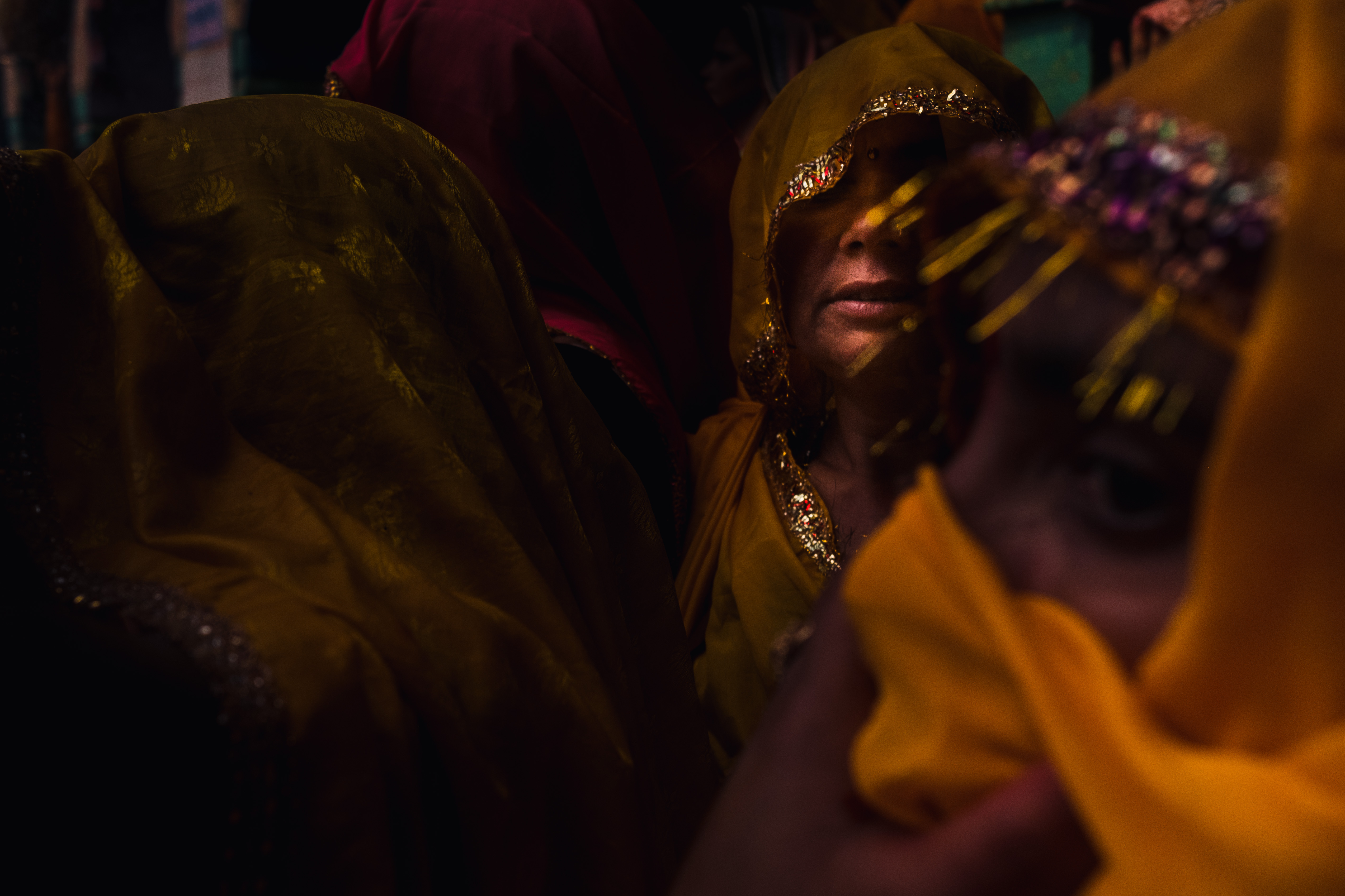 India Street Photography During Holi Festival. ladies hidden face in a sliver of light. Images by Jason Vinson