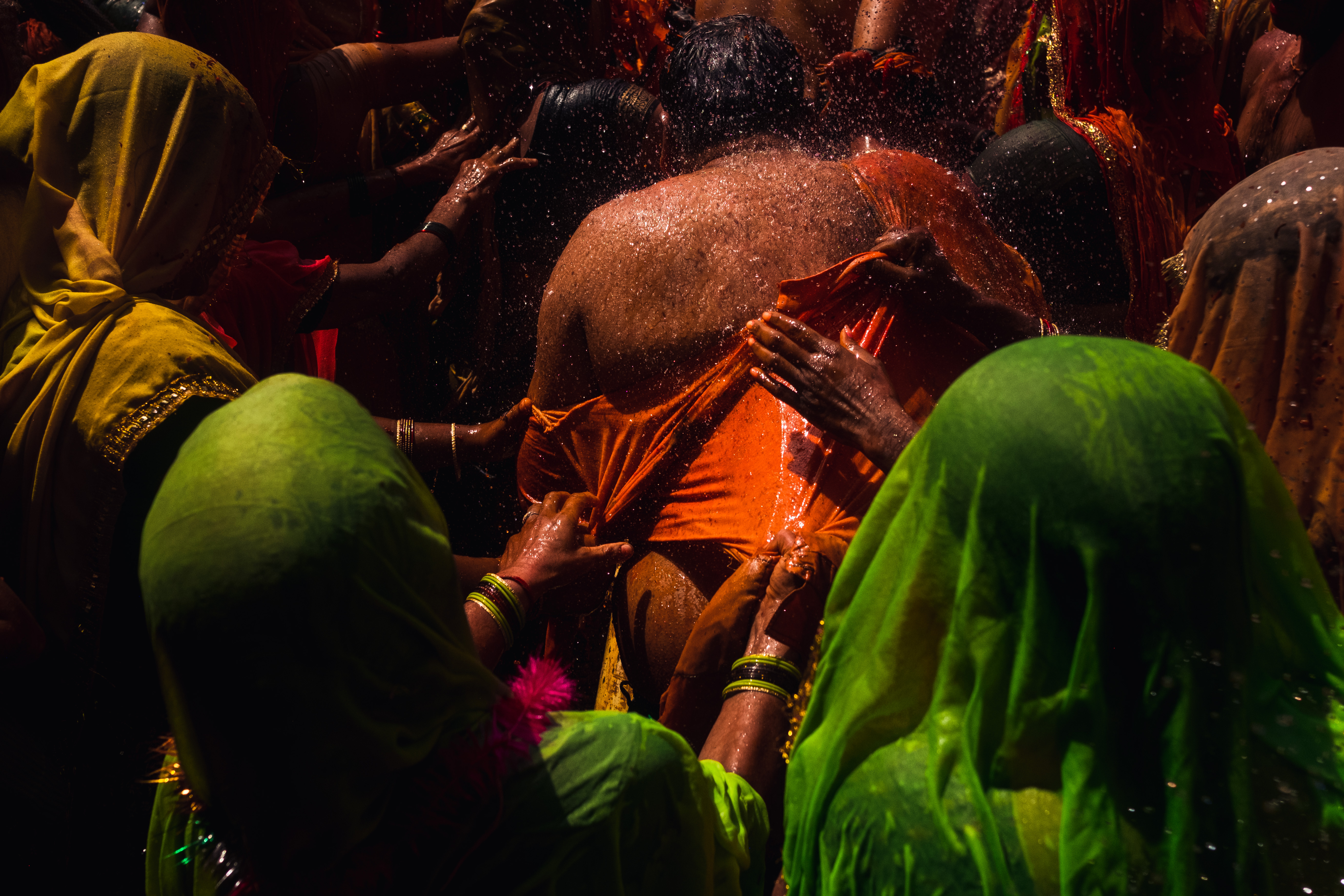 India Street Photography During Holi Festival. man gets his wet shirt ripped off by woman. Images by Jason Vinson