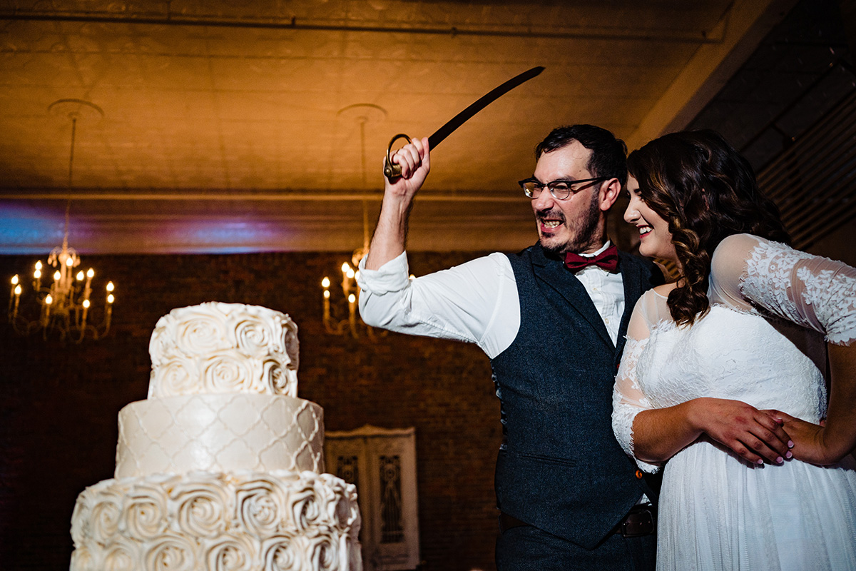 Centerton-Arkansas-Wedding-The-Ravington-NWA-Wedding-groom-cutting-cake-with-sward
