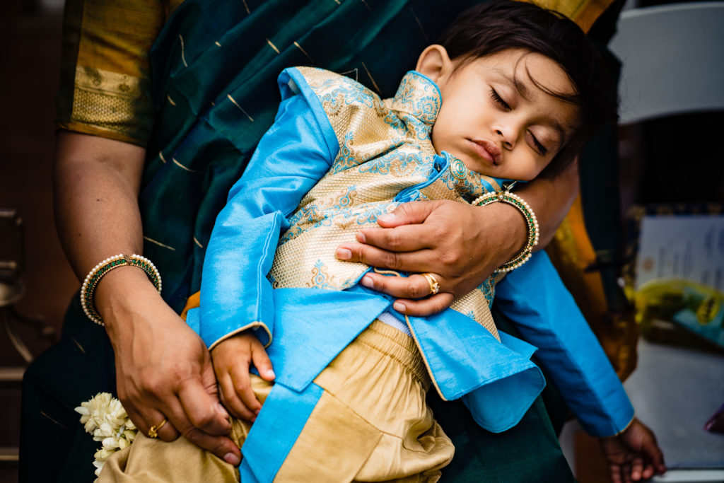 Northwest Arkansas Indian Wedding Photography Vinson Images- child gets bored waiting for ceremony to start and falls asleep in his moms lap