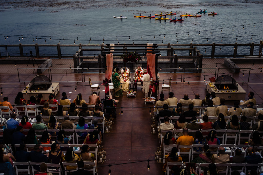 Northwest Arkansas Indian Wedding Photography Vinson Images- overhead view of the ceremony with ocean in the background as canoes paddle by