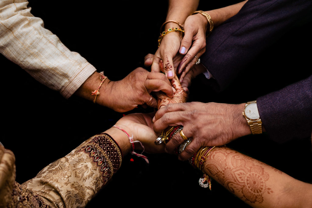 Northwest Arkansas Indian Wedding Photography Vinson Images- group of hands as the brides family hands their daughter over to the groom