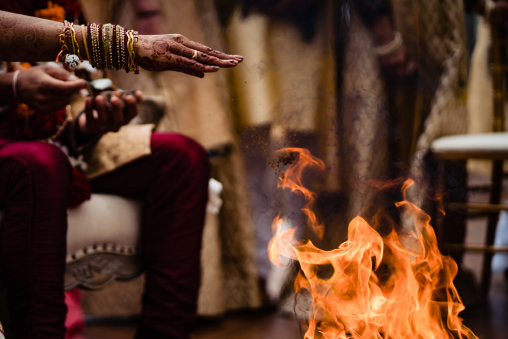 Northwest Arkansas Indian Wedding Photography Vinson Images- bride places things into fire as part of ceremony 