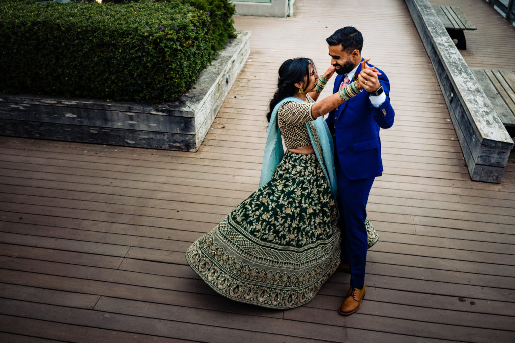 Northwest Arkansas Indian Wedding Photography Vinson Images- bride and groom dance on Monterrey California boardwalk  