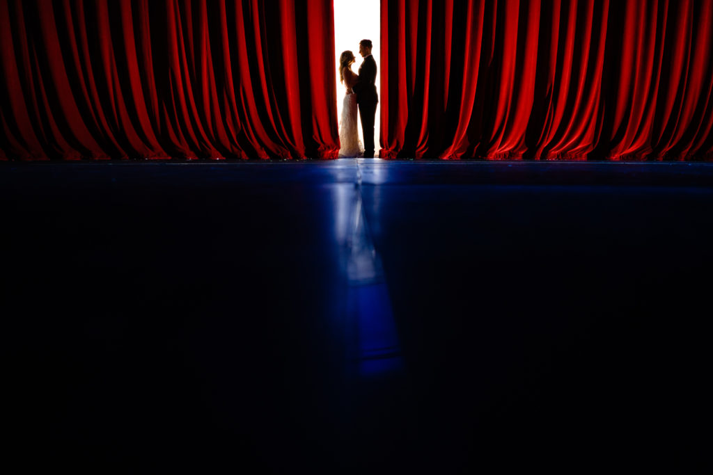 Walton Arts center wedding by Vinson Images - Northwest Arkansas Wedding photography - silhouette with red stage curtains
