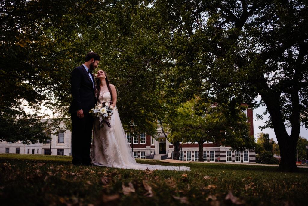 Fayetteville Arkansas Wedding - Old Main Lawn ceremony - bride laughs at groom on lawn