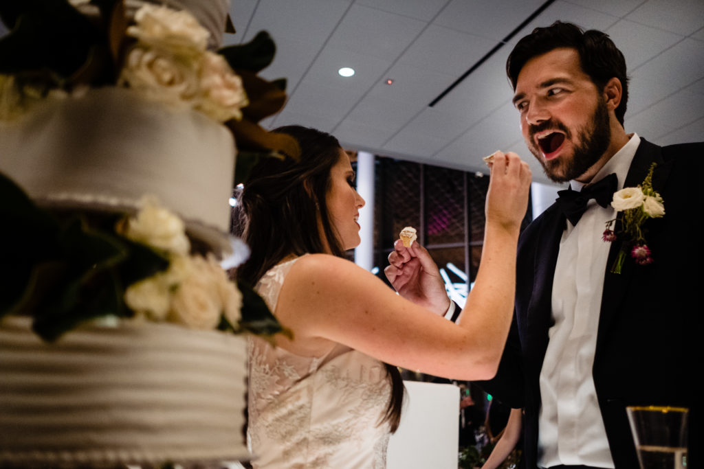 Vinson Images - Walton Arts Center Wedding - bride feeds cake to groom