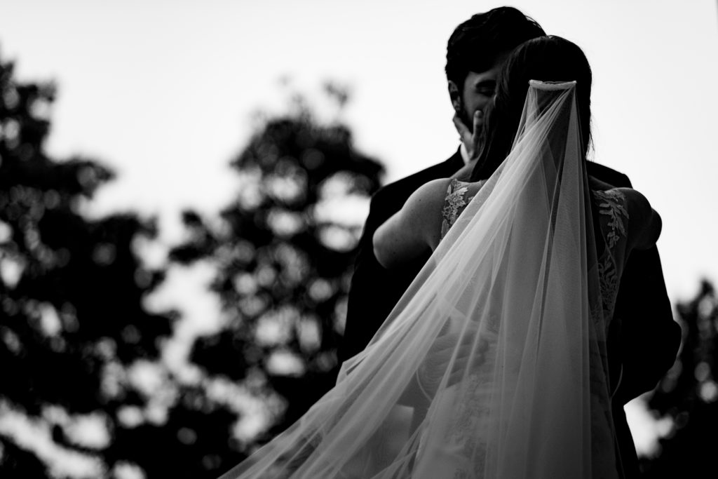 Fayetteville Arkansas Wedding - Old Main Lawn ceremony - brides veil as she kisses groom