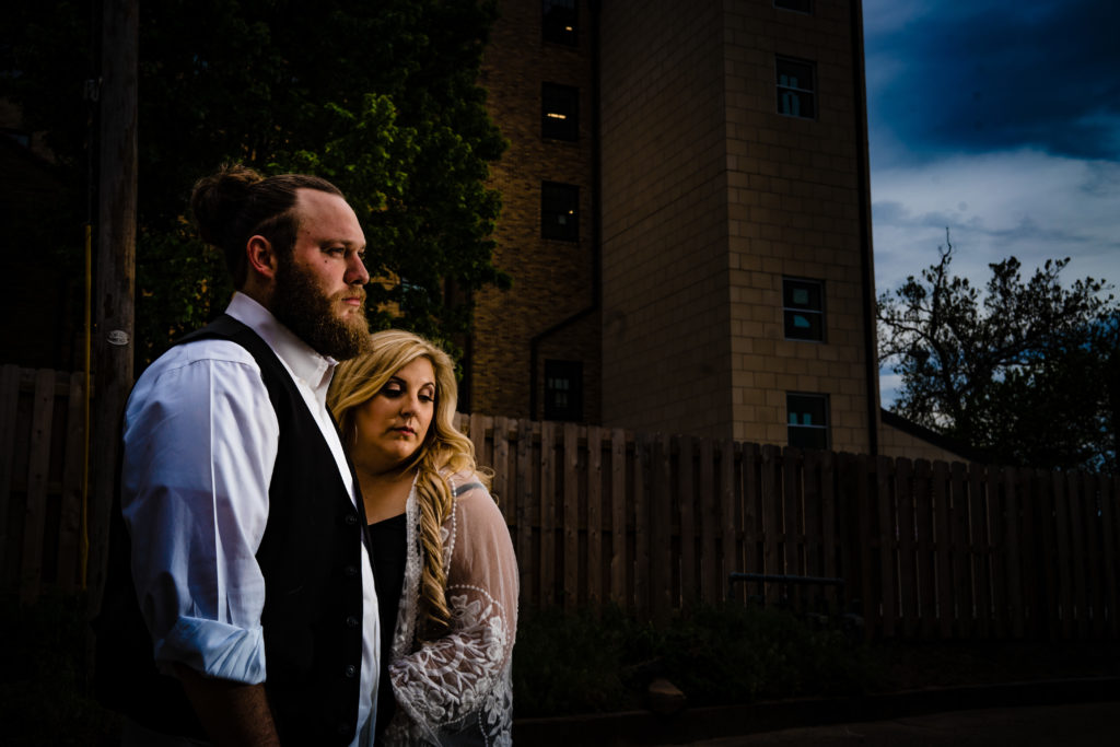 Northwest Arkansas Wedding Photography - Vinson Images - Downtown Rogers Engagement - couple in front of fence