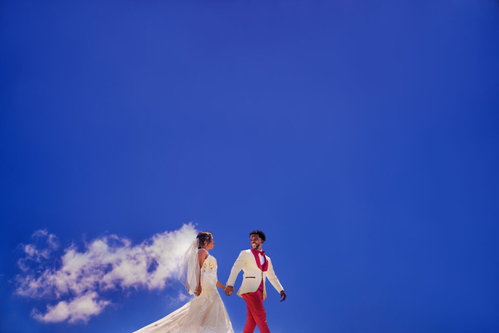 A cloud resembles a brides veil and she walk with her groom 