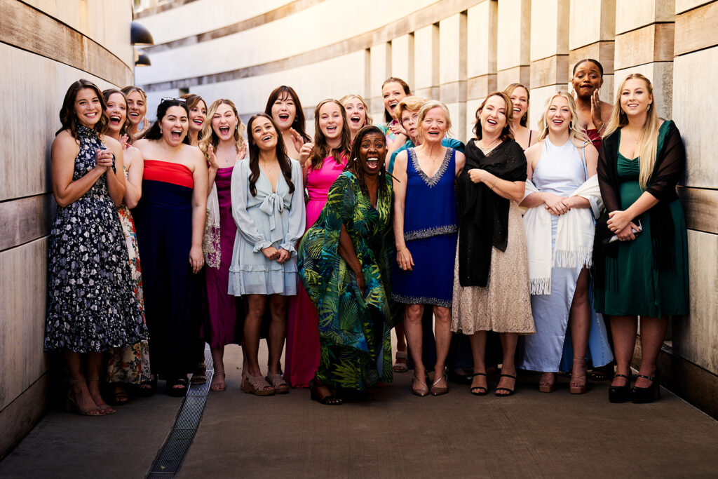 Bride reveals her dress to girlfriends outside the main entrance of Crystal Bridges Museum of American Art